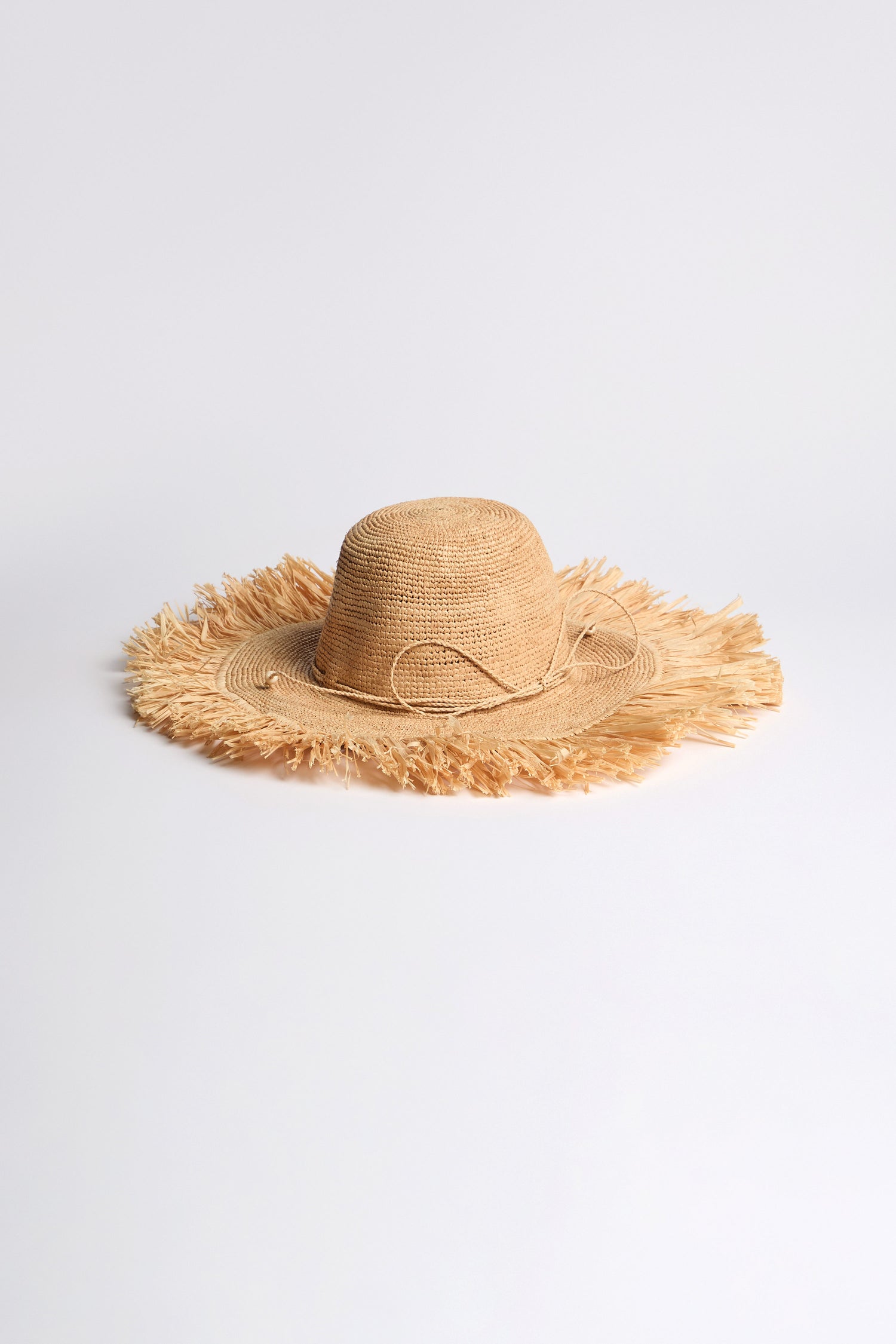 Handmade Raffia Straw Fringe Hat, made from sustainably harvested raffia with a wide frayed brim—ideal for sunny holidays. Shown on a plain white background.