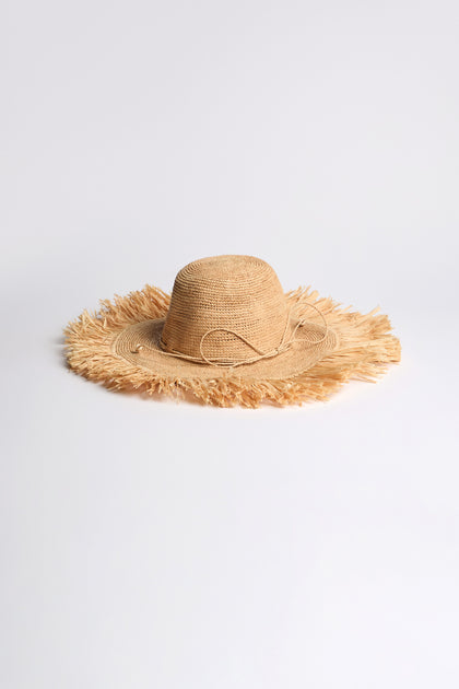 Handmade Raffia Straw Fringe Hat, made from sustainably harvested raffia with a wide frayed brim—ideal for sunny holidays. Shown on a plain white background.