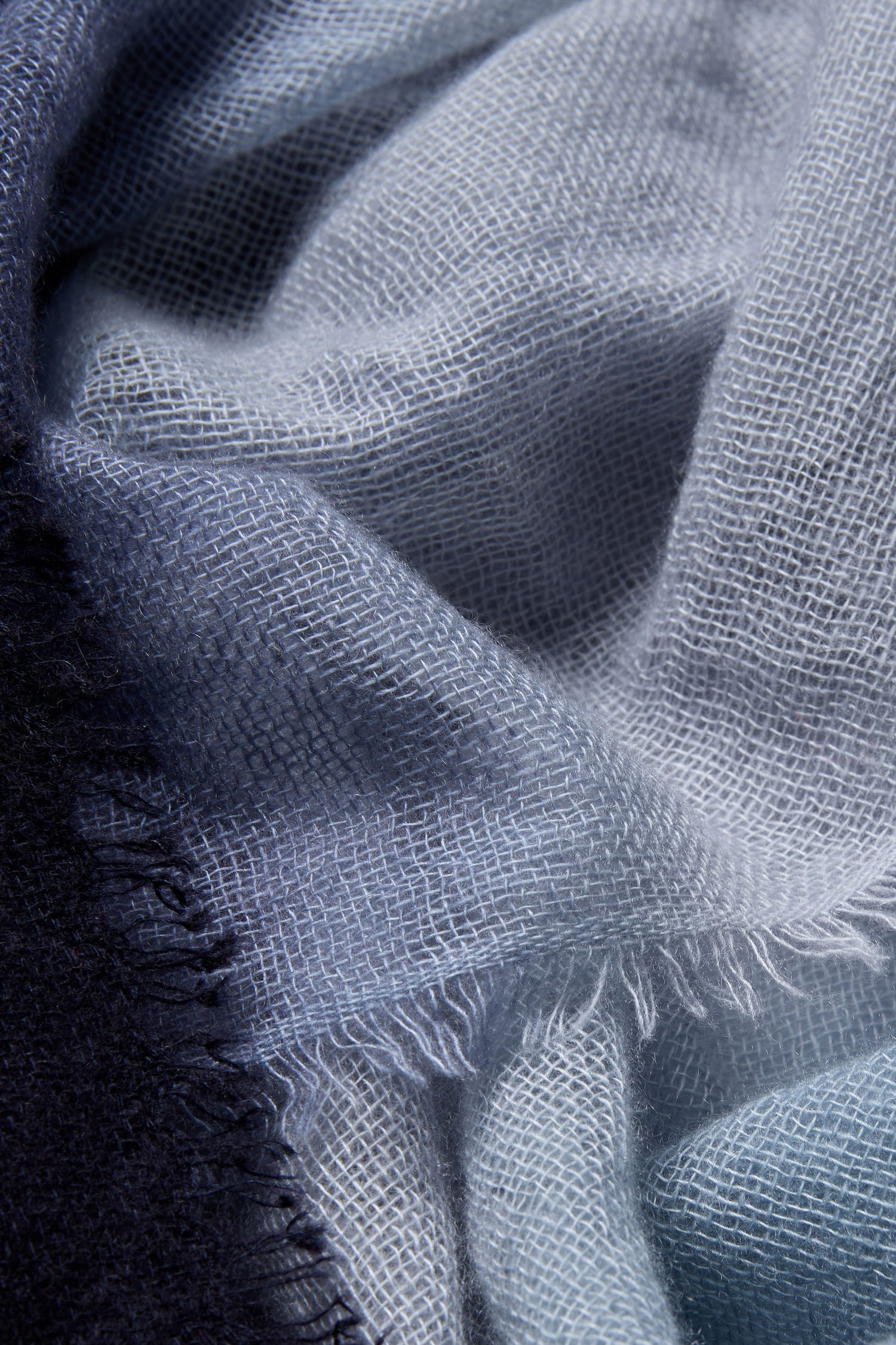 Close-up of the Blue and Grey Soft Colourblend Cashmere Shawl, woven in Nepal, showcasing its visible texture and fringed edges.