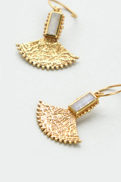 The Gold Plated White Moonstone Mini Fan Earrings feature fan-shaped textured gold-plated pendants with rectangular white moonstone settings, shown against a light background.