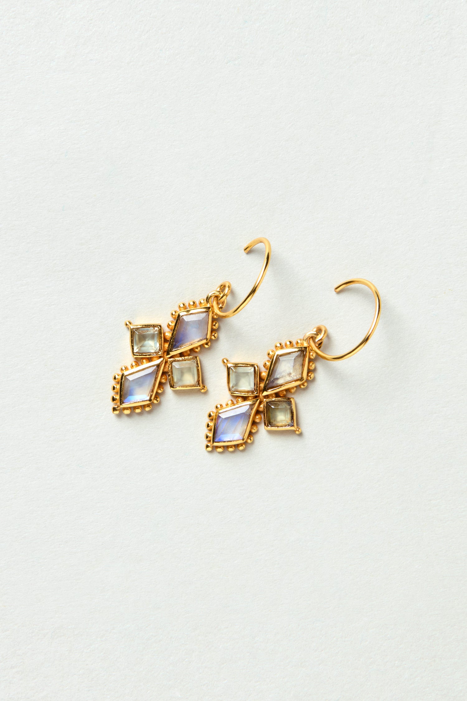Gold Plated White Moonstone Kite Earrings in a diamond-shaped design, set in a decorative gold frame and displayed on a light background.