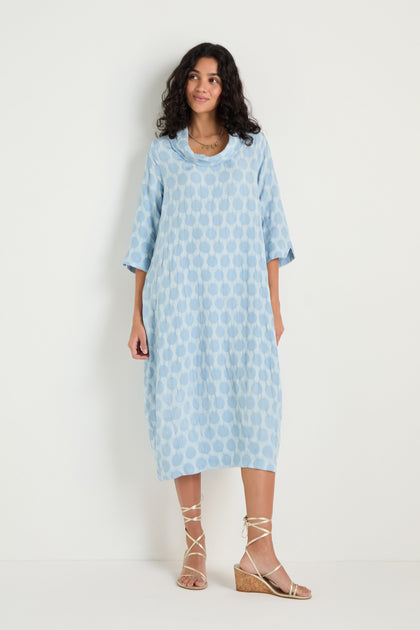 A woman wears the Spot Textured Jacquard Bubble Dress in light blue with three-quarter sleeves and lace-up wedge sandals, standing against a plain white background.