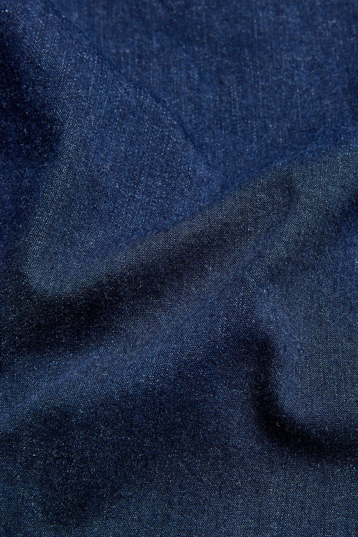 A close up image of a dark blue Stretch Denim Bubble Trouser fabric.