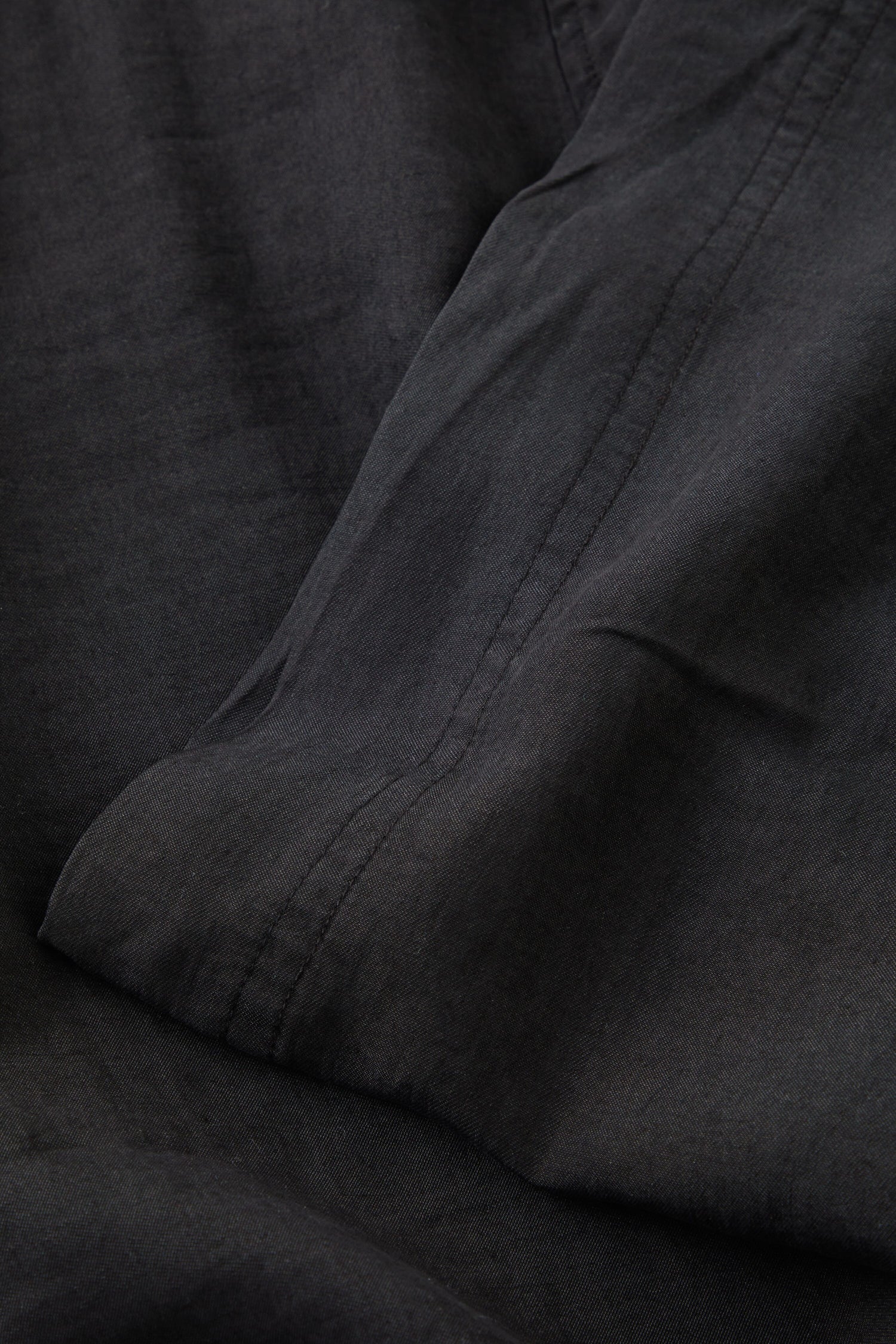 A close up image of a black bed sheet made from Soft Tencel Wide Trouser fabric.