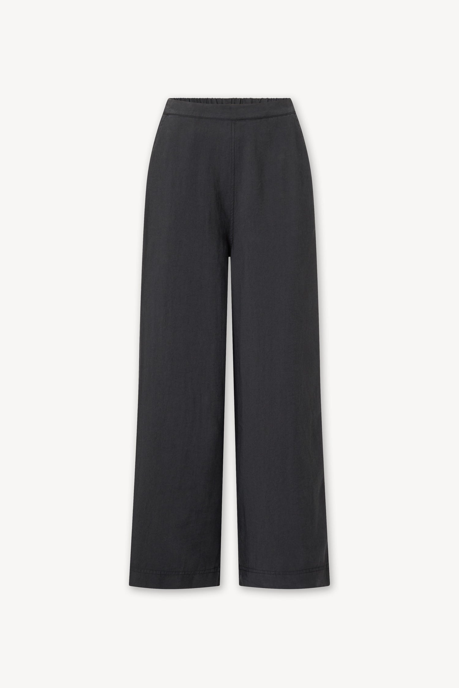 A woman wearing Soft Tencel Wide Trousers with an elasticated waistband, made from TENCEL LYOCELL fabric.