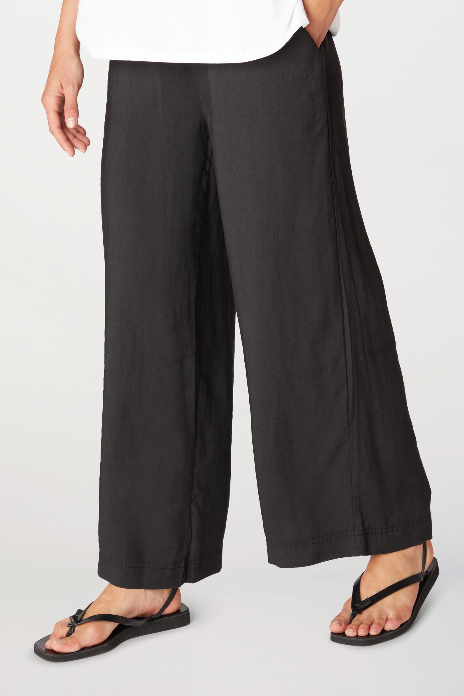 A woman wearing Soft Tencel Wide Trousers with an elasticated waistband.