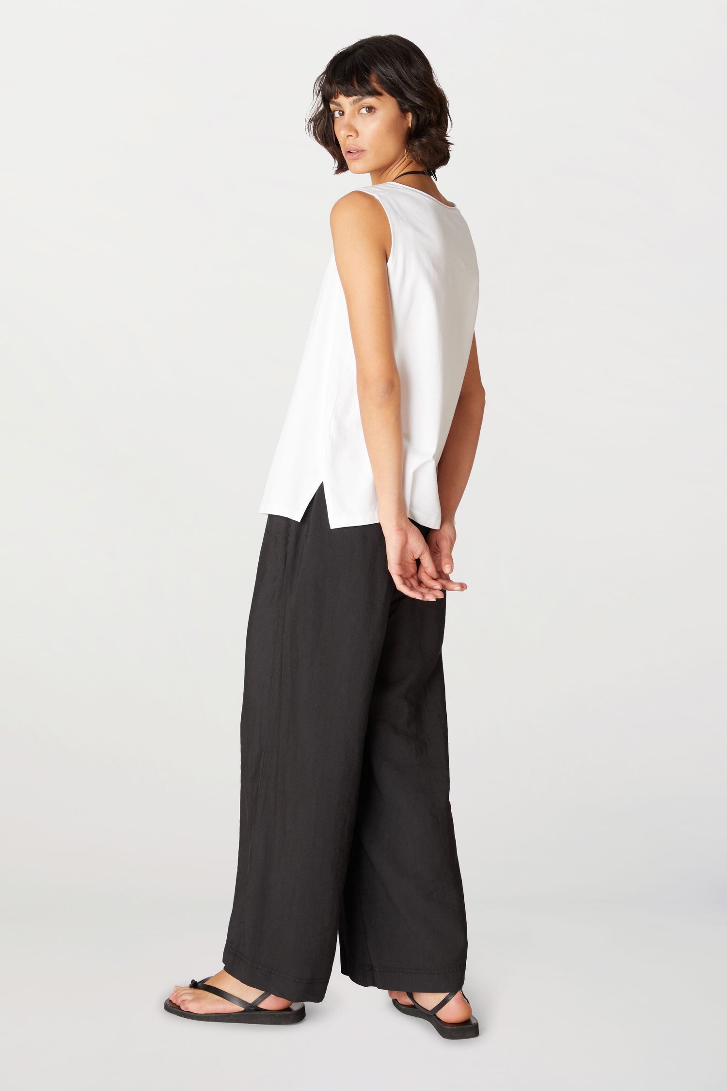 A woman in Soft Tencel Wide Trousers made from TENCEL LYOCELL fabric, featuring an elasticated waistband.