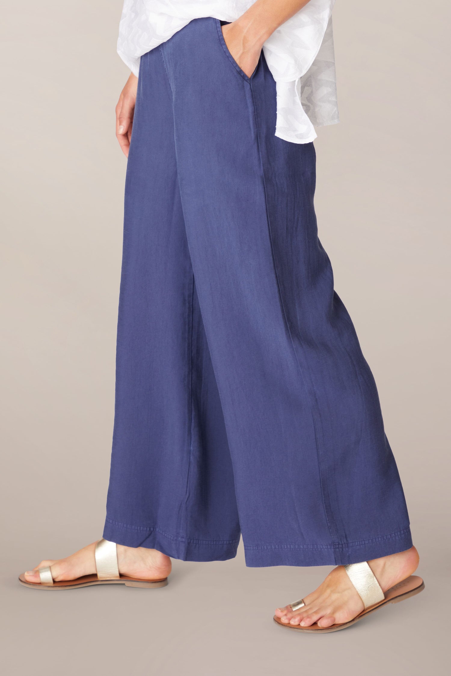 A woman wearing Soft Tencel Wide Trousers with an elasticated waistband.