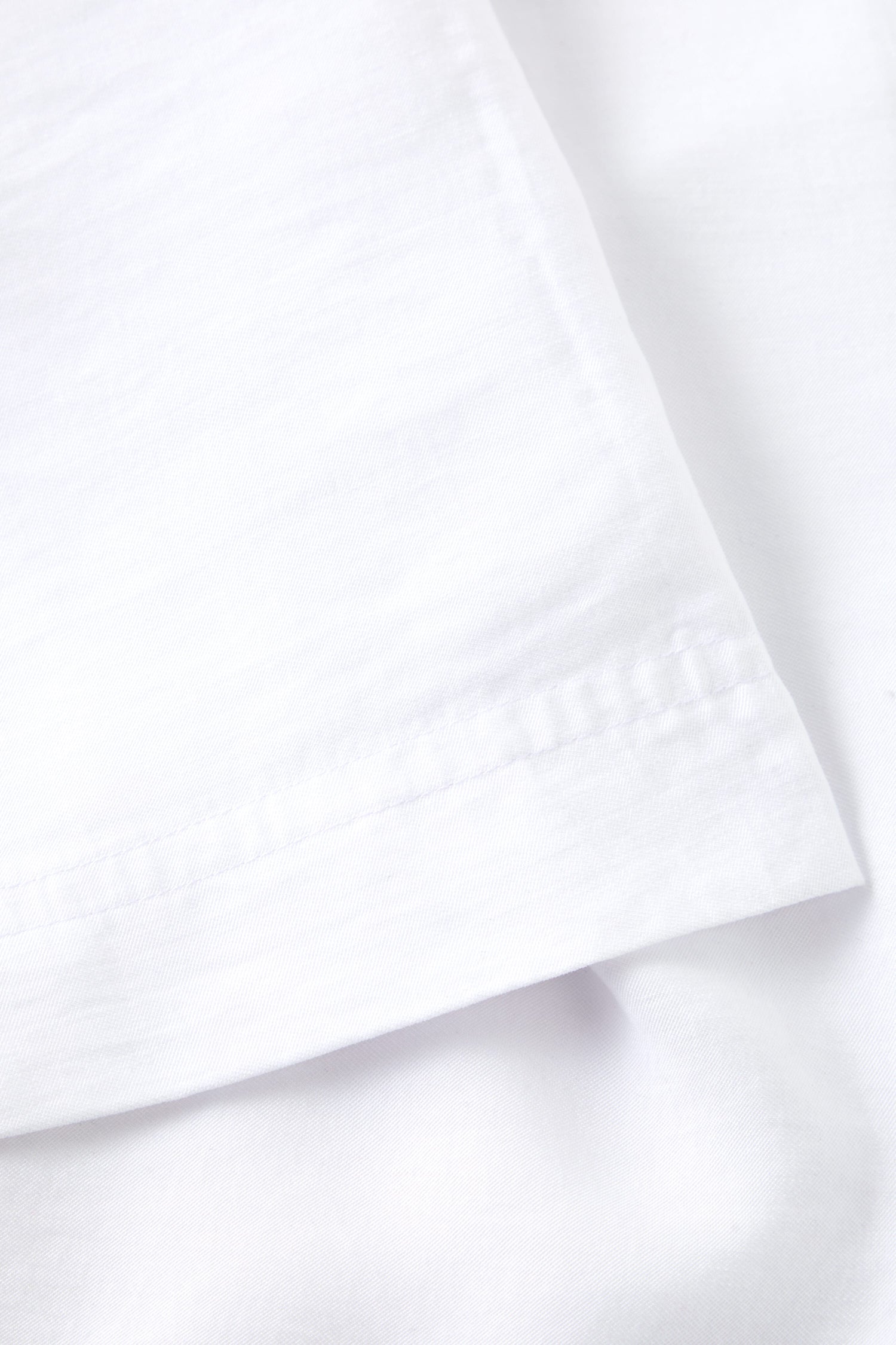 A close up image of a white bed sheet made of Tencel Lyocell fabric. 
