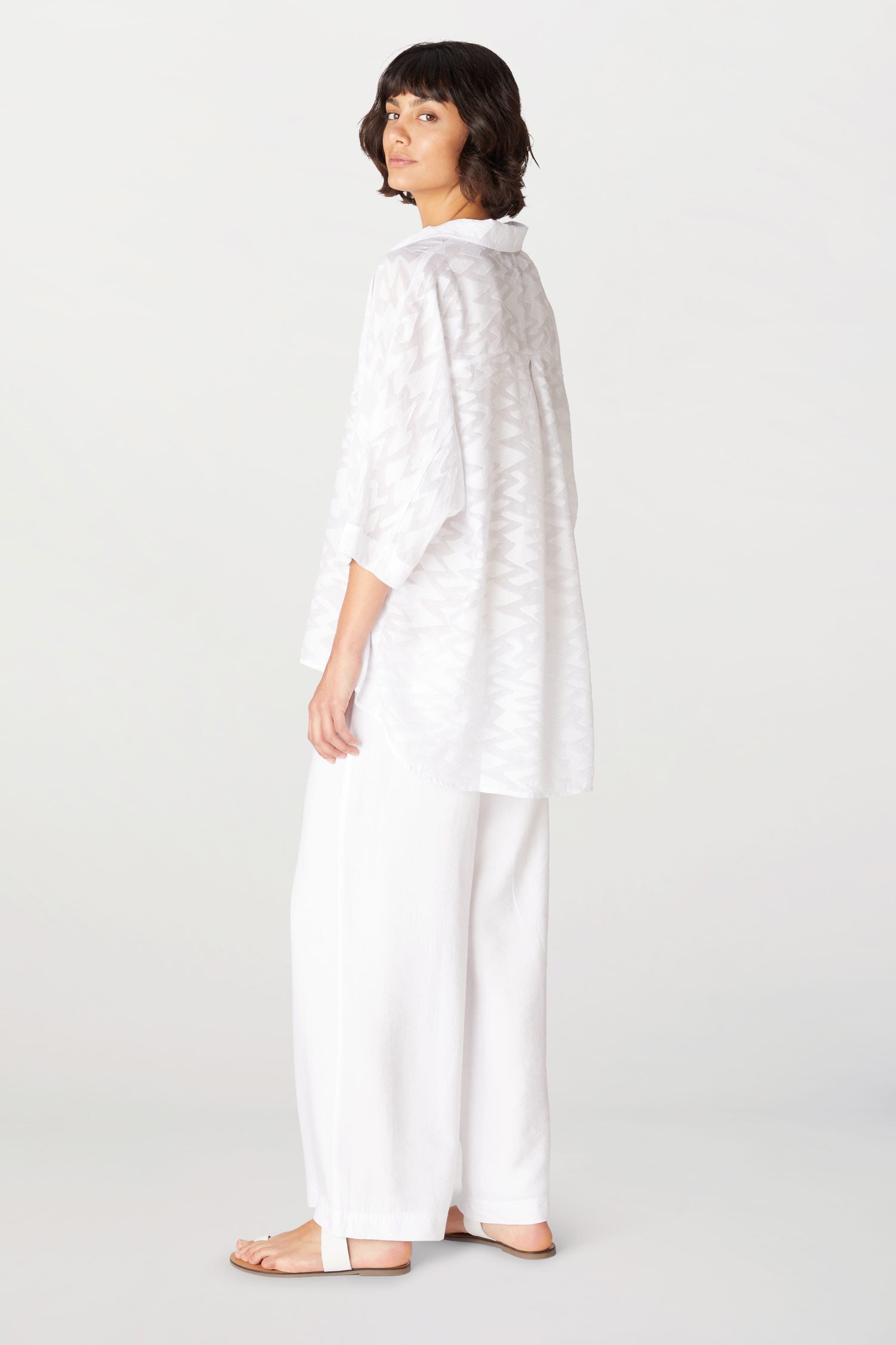 The back view of a woman wearing Soft Tencel Wide Trousers with an elasticated waistband and made of TENCEL LYOCELL fabric.