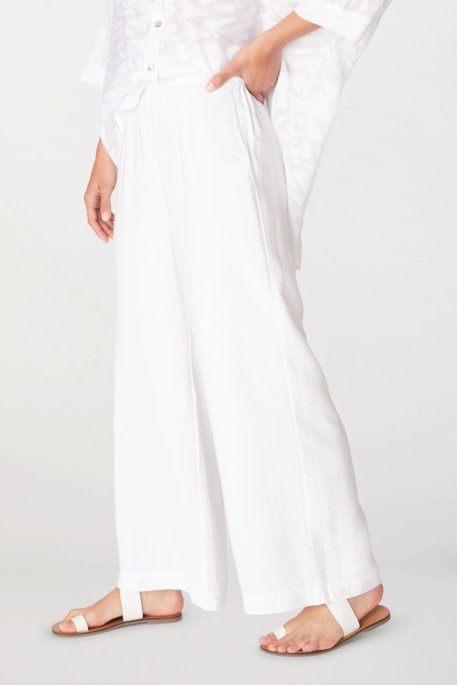 A woman wearing Soft Tencel Wide Trousers made of TENCEL LYOCELL fabric, paired with sandals.