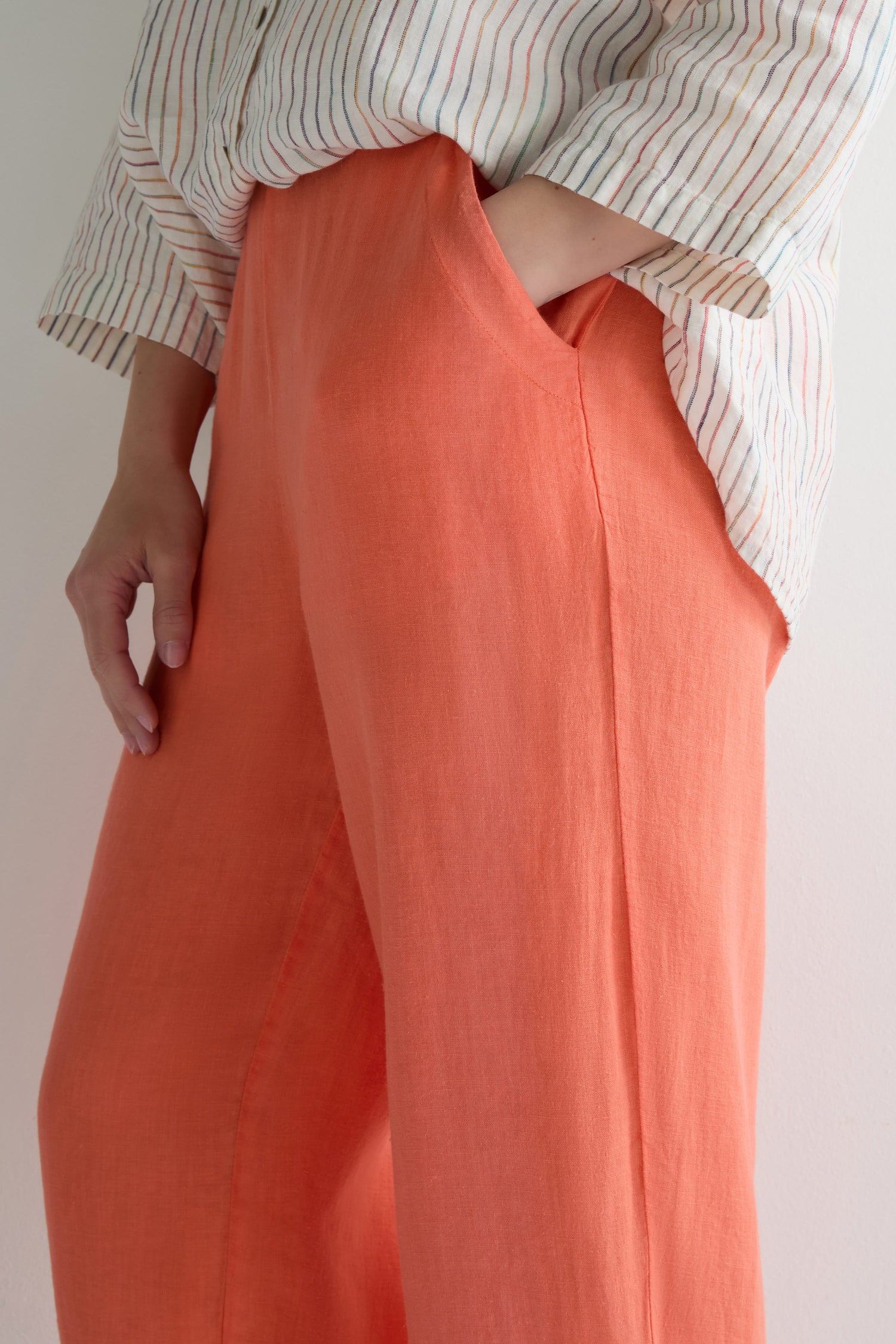 A person stands against a plain light background, wearing an off-white striped long-sleeve shirt and Linen Tulip Hem Bubble Trouser with a relaxed fit, one hand in the pocket.