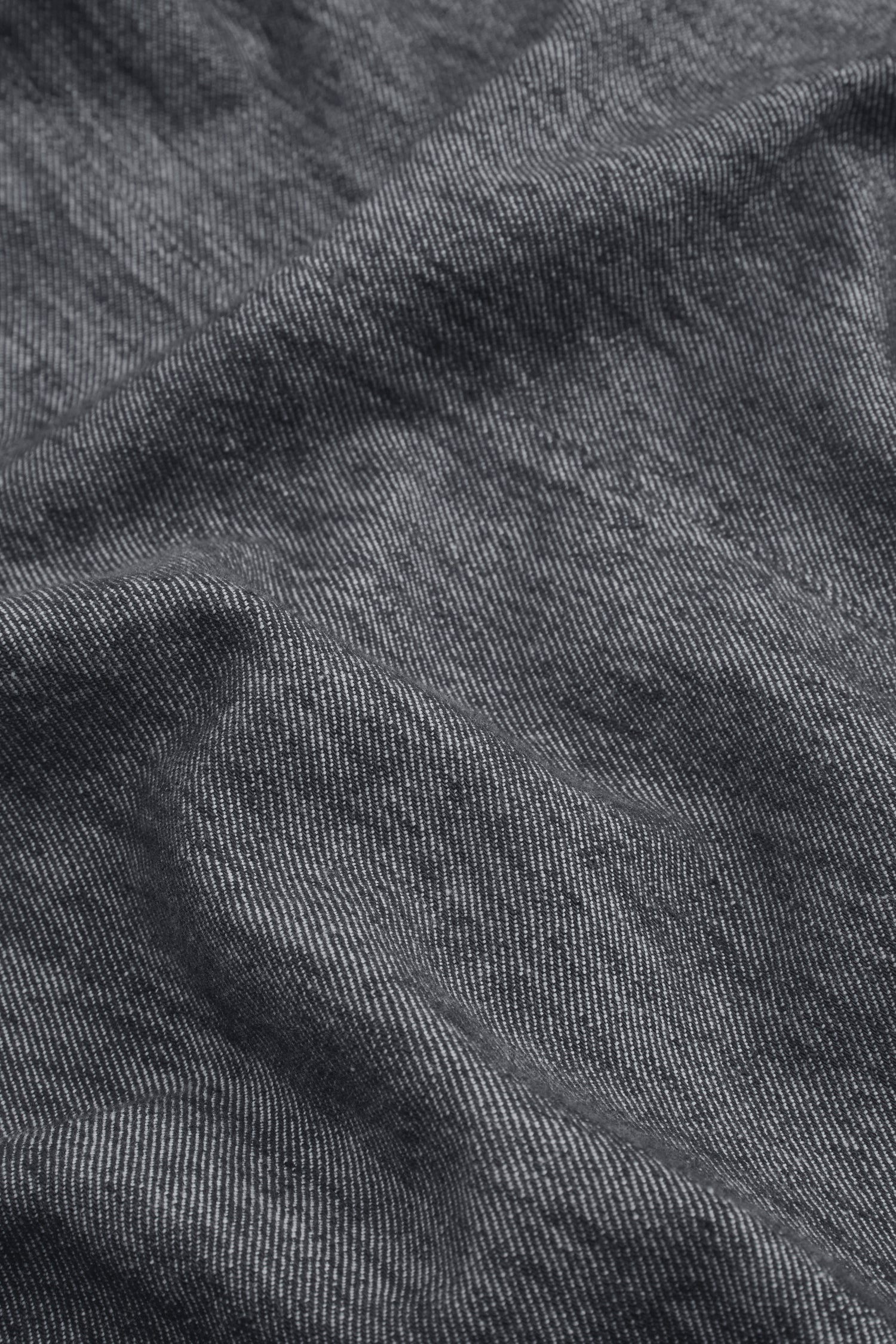 Close-up of blue and white pinstriped fabric with visible texture and gentle folds, characteristic of the Washed Cotton Linen Barrel Trousers featuring an elasticated waist.