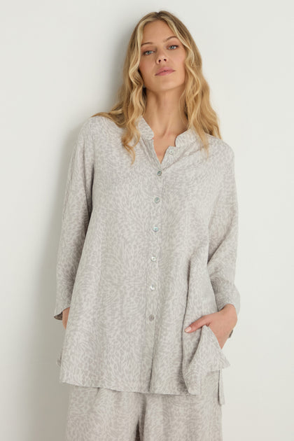 A woman stands against a white background wearing the Animal Textured Jacquard Nehru Shirt, a loose, light-colored viscose blend button-up with subtle animal jacquard, paired with matching pants.