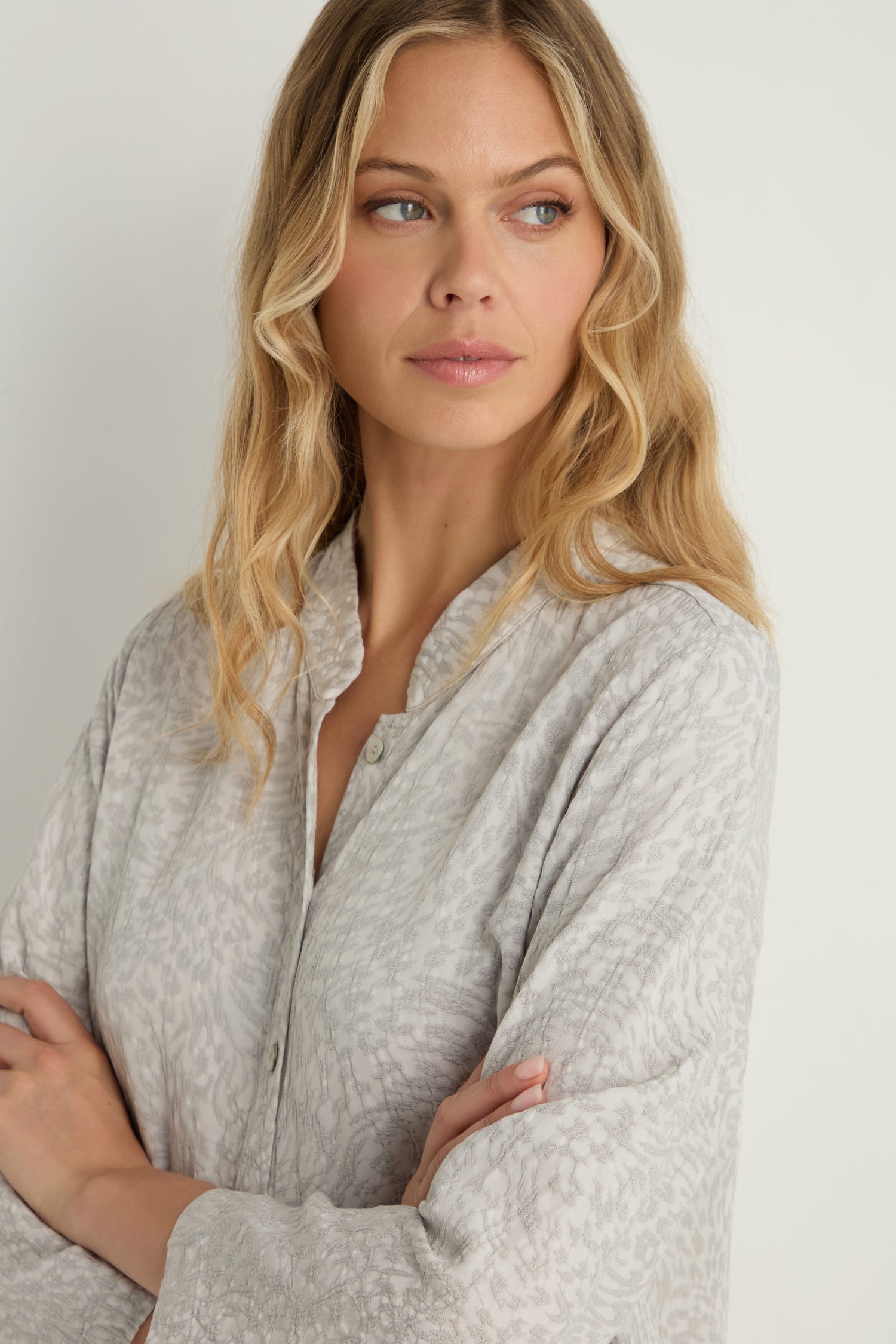 A woman with long blonde hair wears the Animal Textured Jacquard Nehru Shirt in light gray, standing with arms crossed and looking to the side.