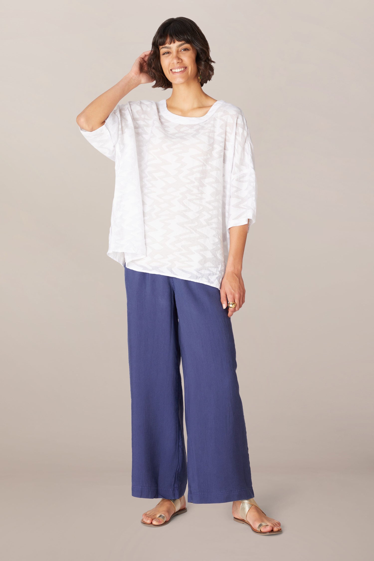 A woman wearing a Zig Zag Jacquard Top and blue wide leg pants.