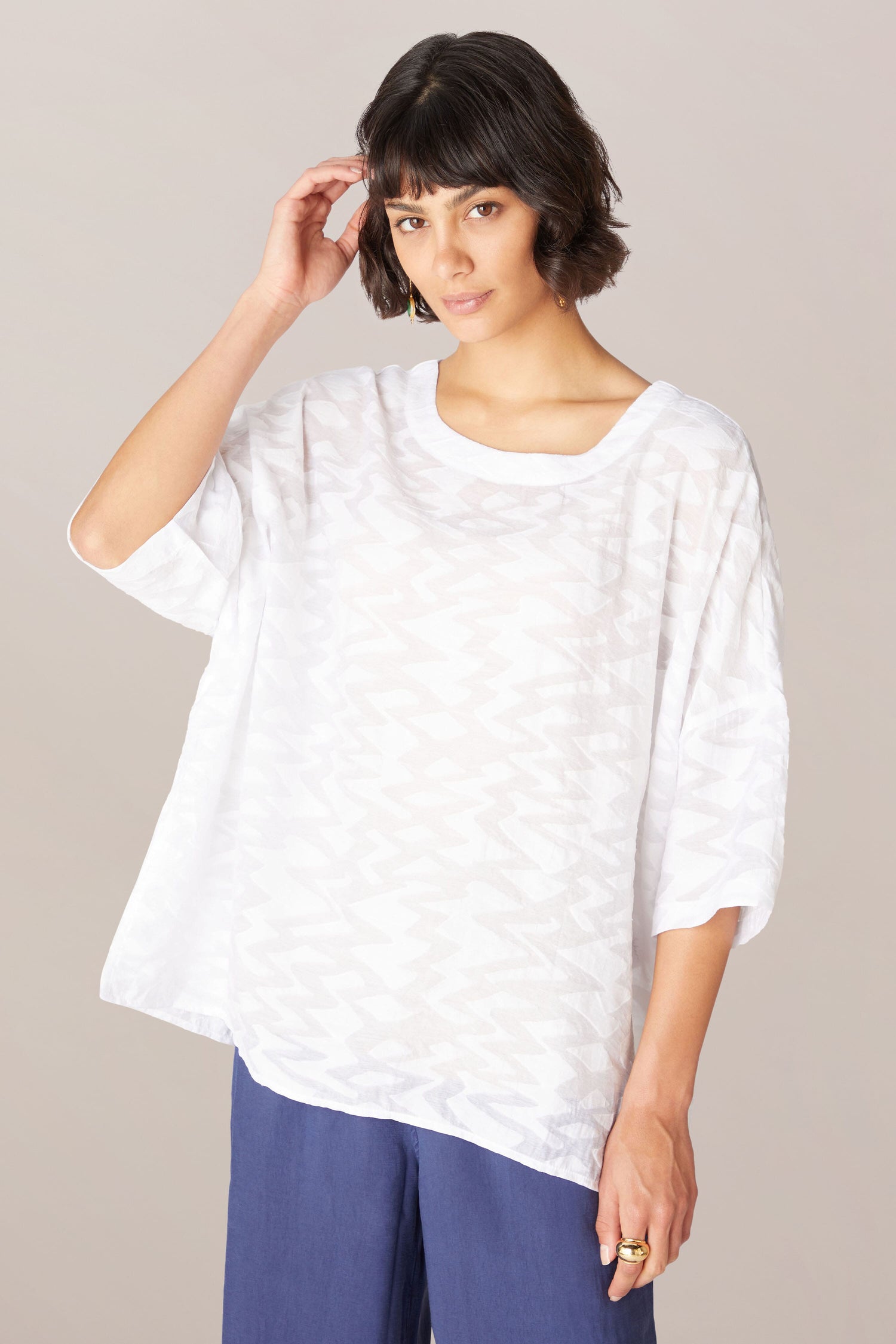 A woman wearing a Zig Zag Jacquard Top and blue pants in a relaxed boxy fit.