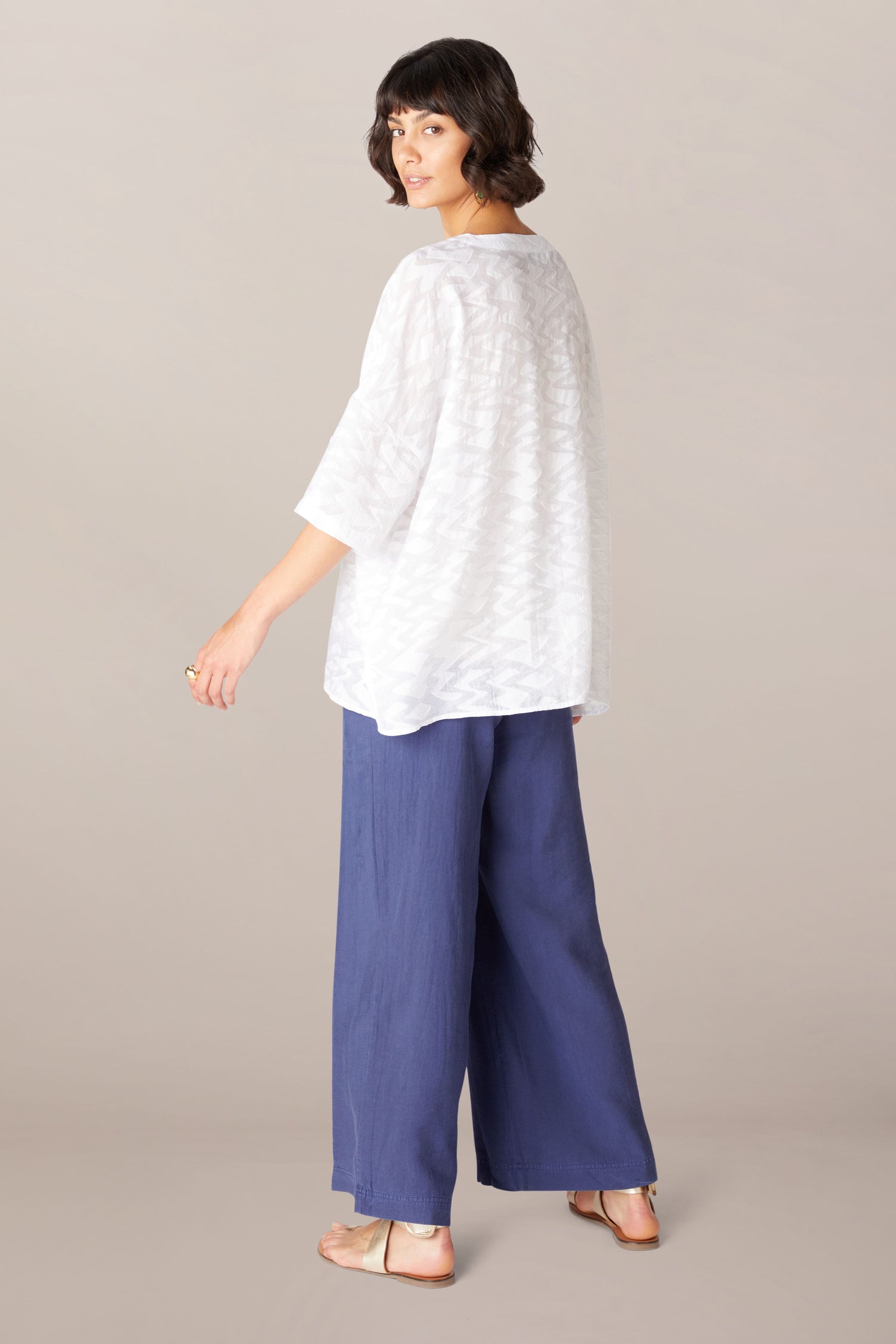 The back view of a woman wearing relaxed boxy fit linen pants and a Zig Zag Jacquard Top.
