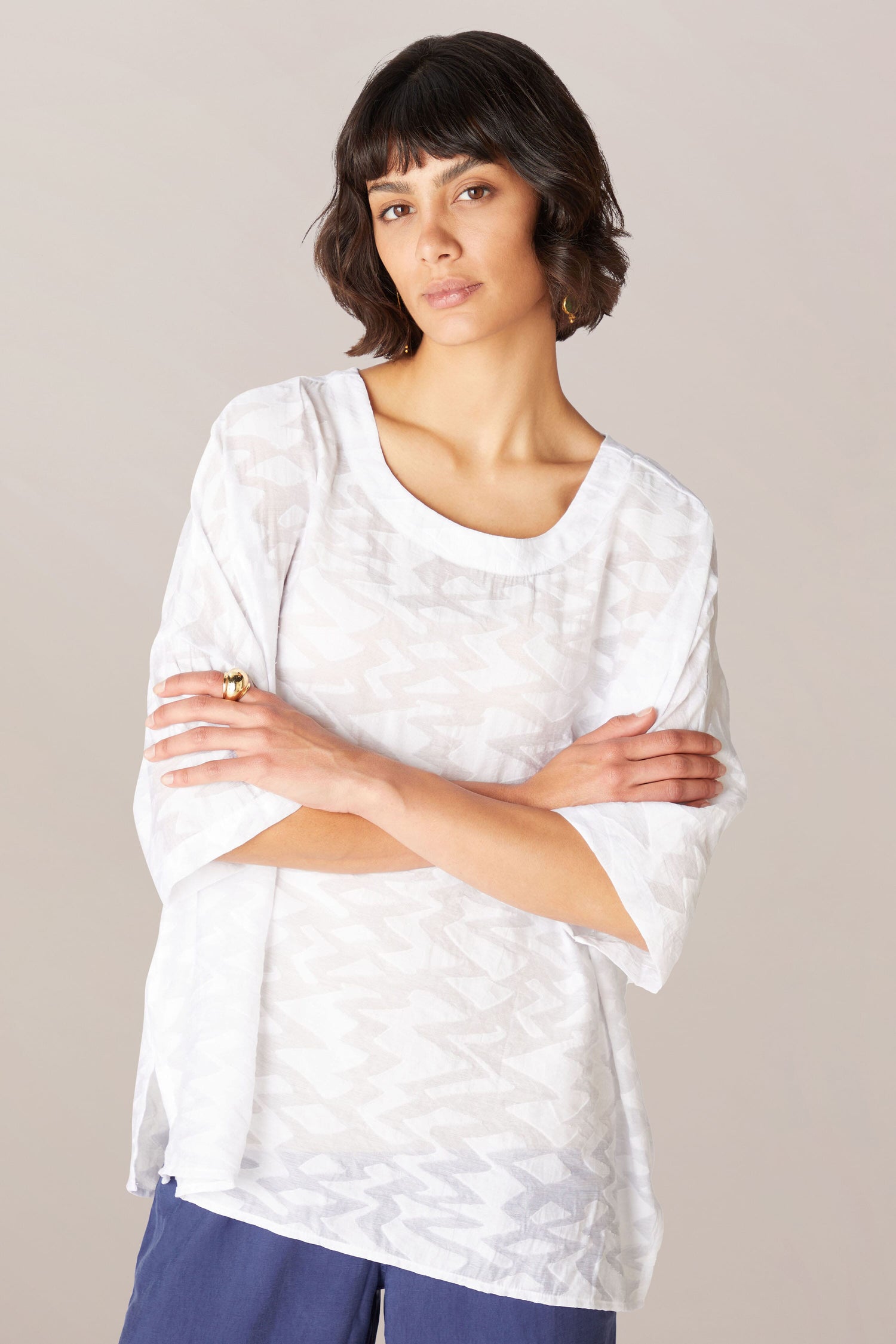 A woman wearing a relaxed boxy fit Zig Zag Jacquard Top and blue pants in a Zig Zag Jacquard pattern, crafted from a lightweight viscose blend fabric.