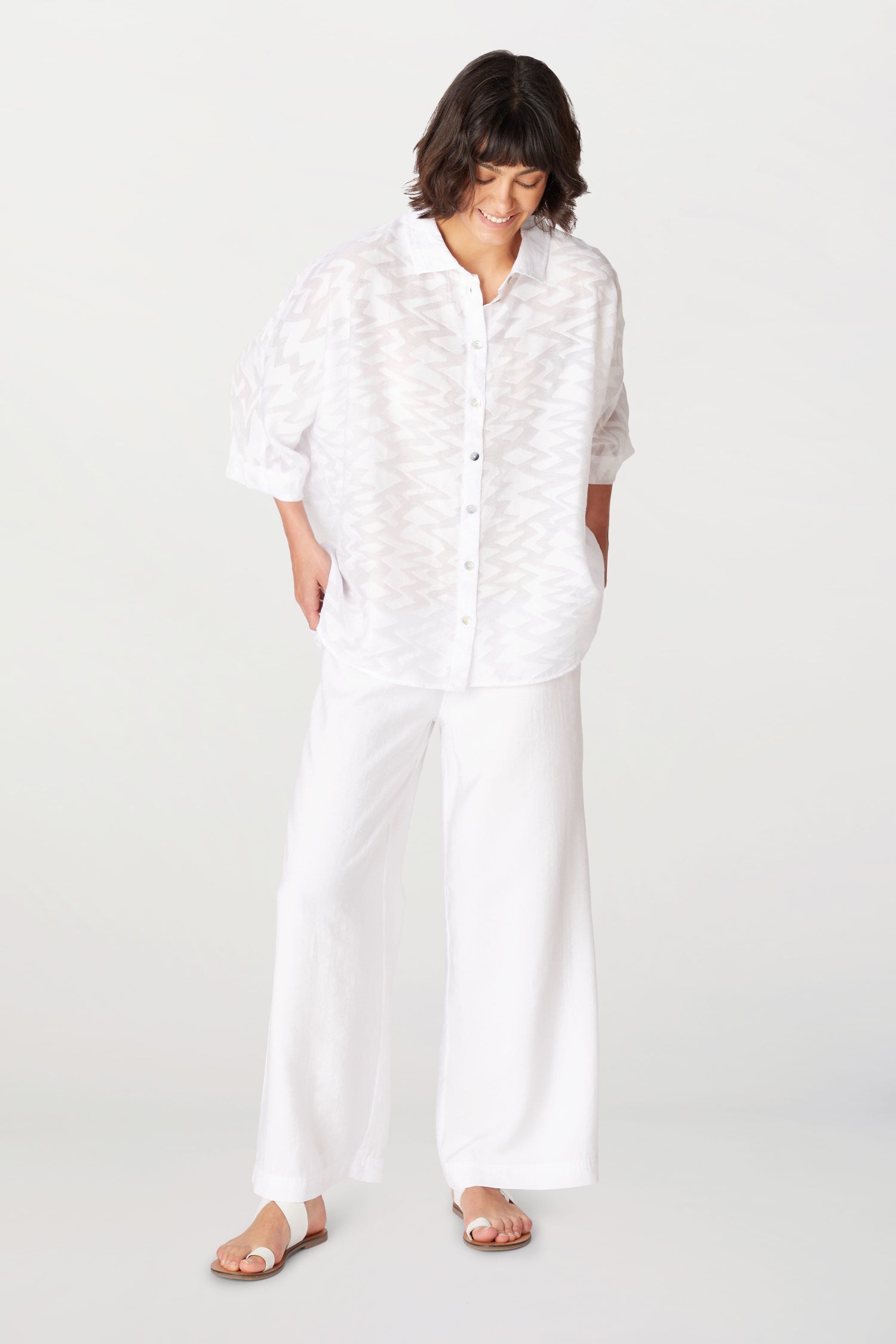 A woman wearing a Zig Zag Jacquard Shirt crafted from a viscose blend, paired with wide leg pants in a Zig Zag Jacquard pattern.