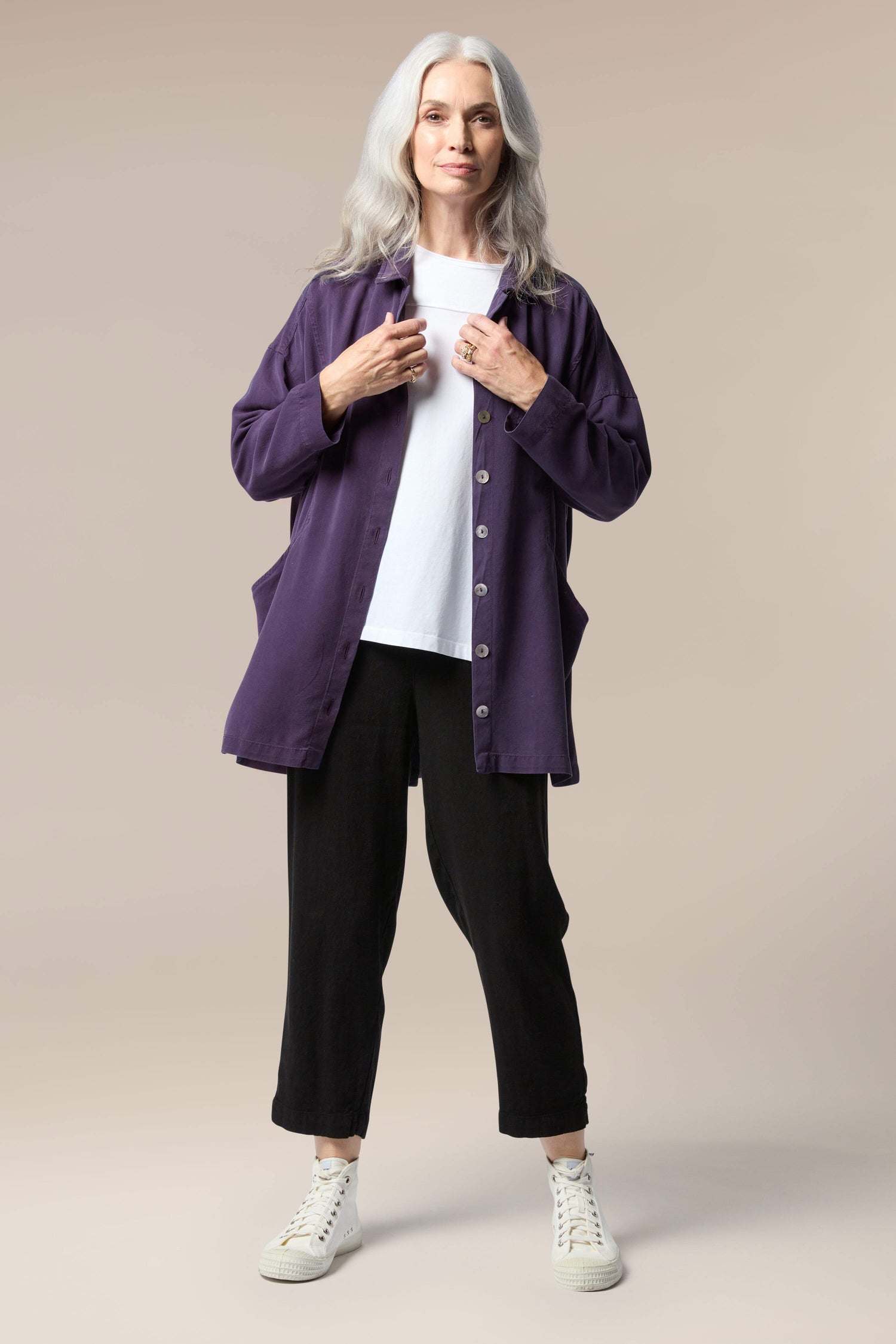 A woman wearing a soft Fluid Twill Relaxed Shirt in a longline silhouette and black pants.
