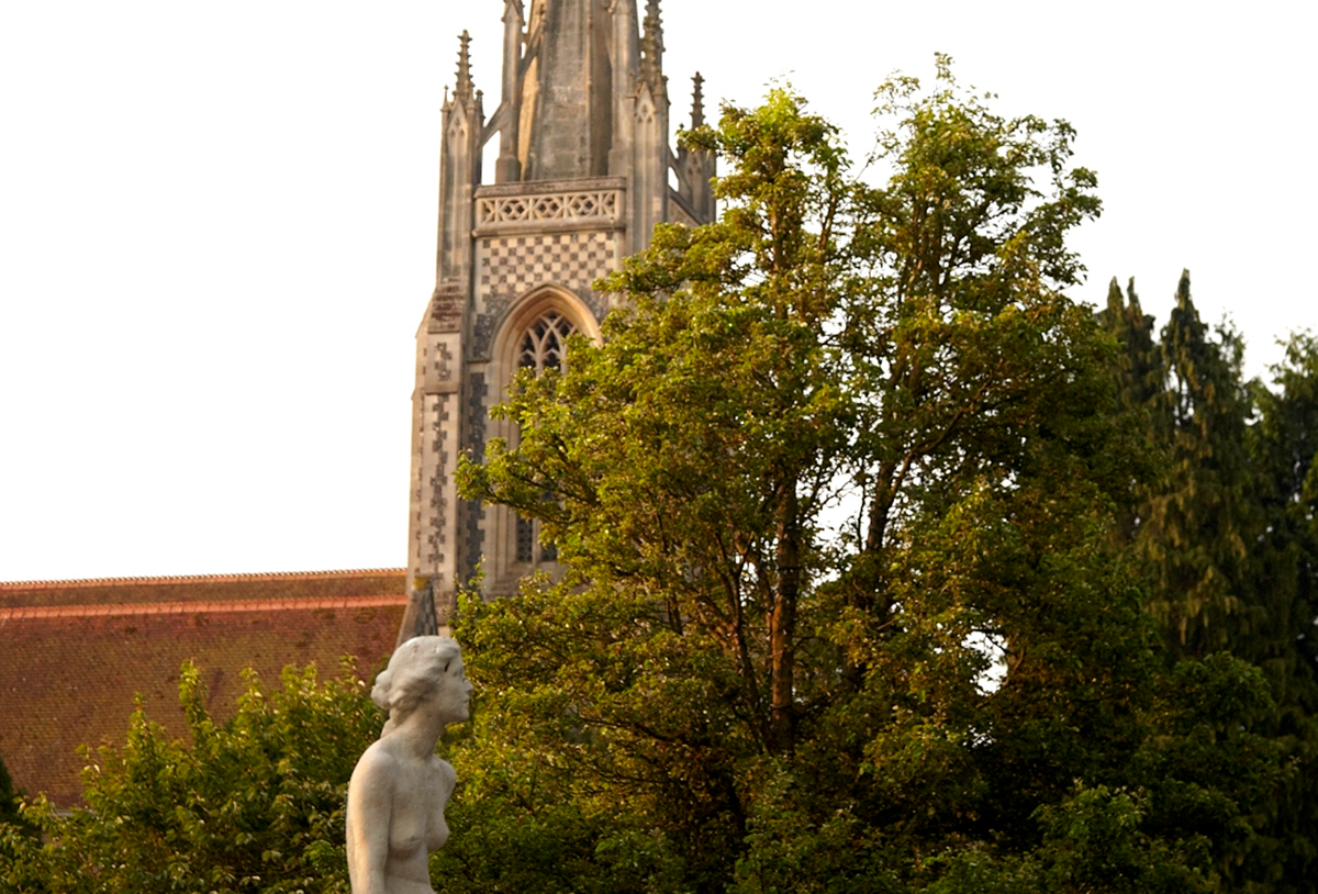 statue of a woman in front of a cathedral 