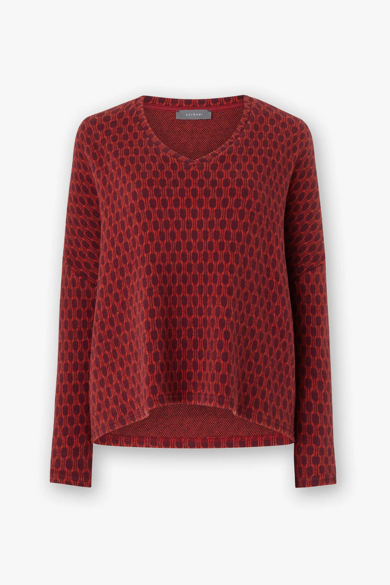 The Honeycomb Top is an oversized red knit sweater with a unique honeycomb pattern, V-neck, and long sleeves set against a white background, highlighting the craftsmanship of Italian artisans.