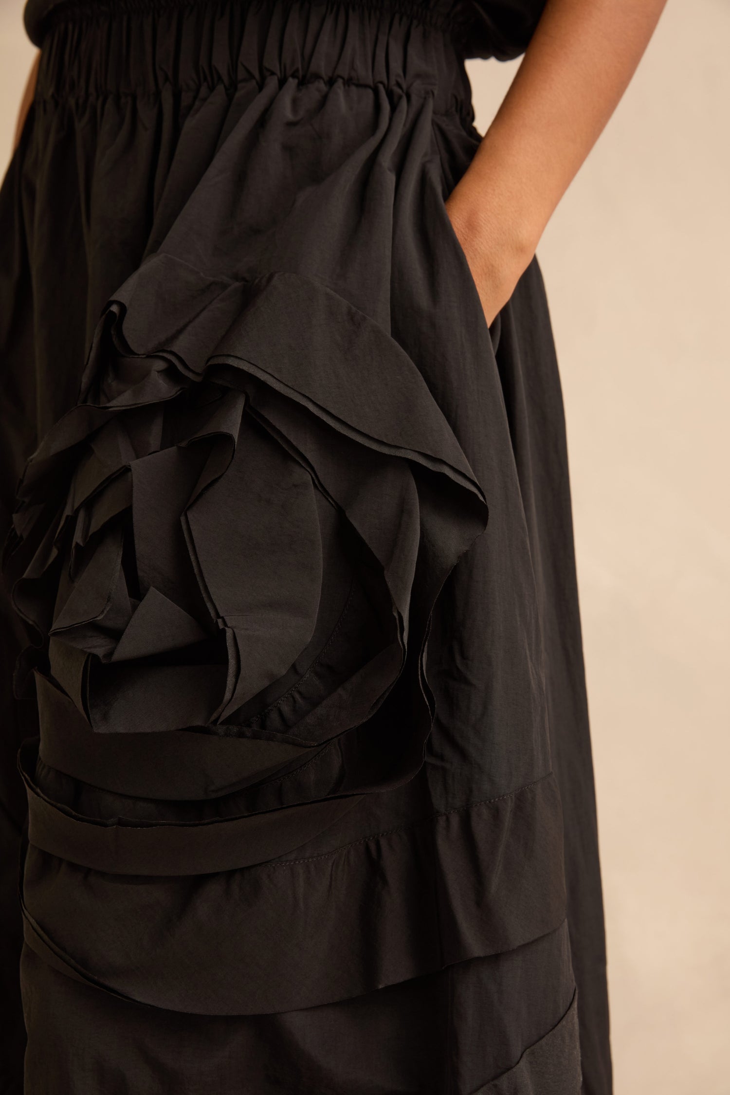 Black Taffeta Bubble Skirt featuring an elastic waistband and a large, dimensional fabric flower detail on the hip.
