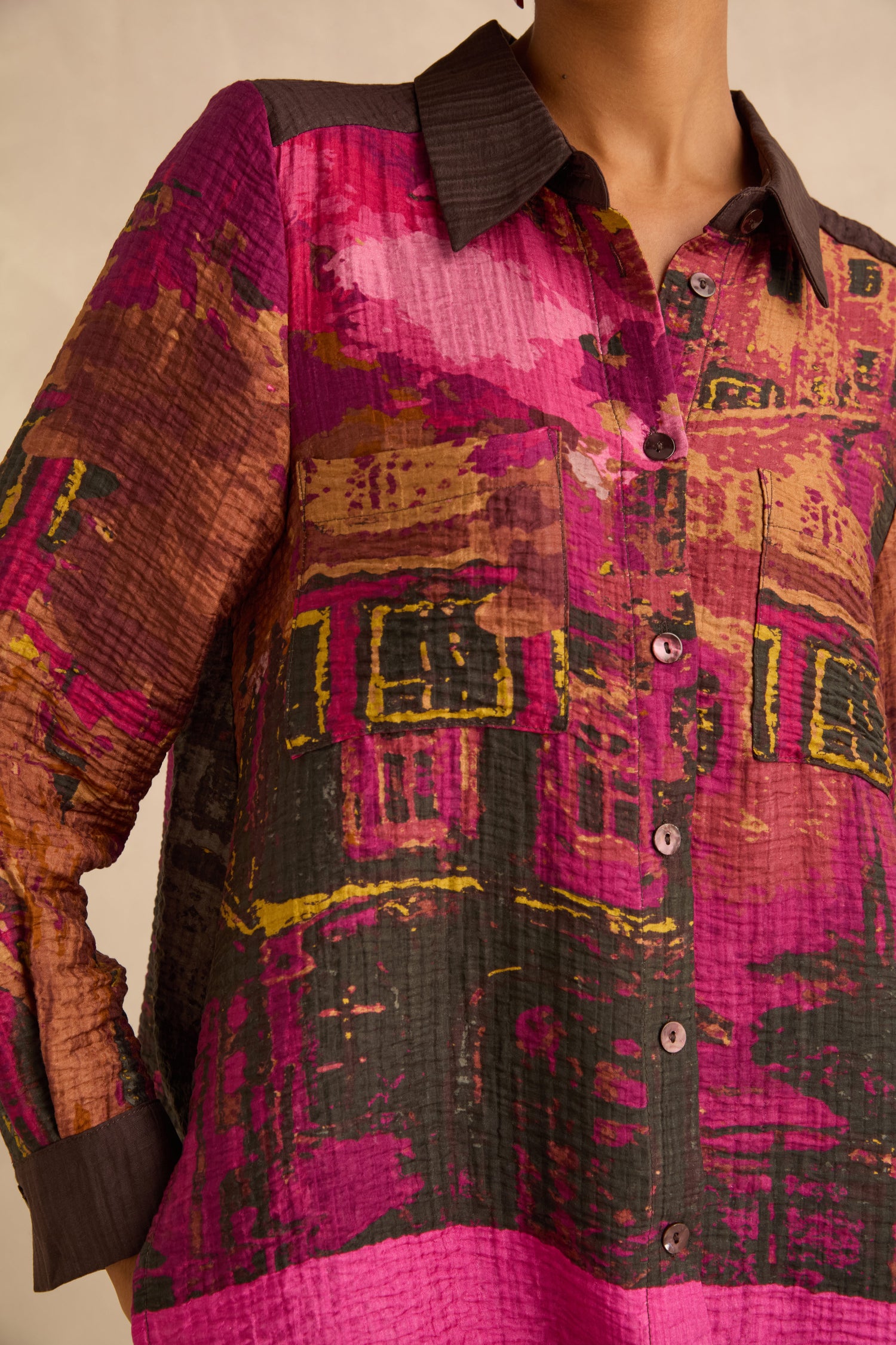 Window Print Pleated Shirt: a lightweight viscose button-down with an abstract architectural block print in pink, brown, and yellow, finished with a dark brown collar and cuffs.