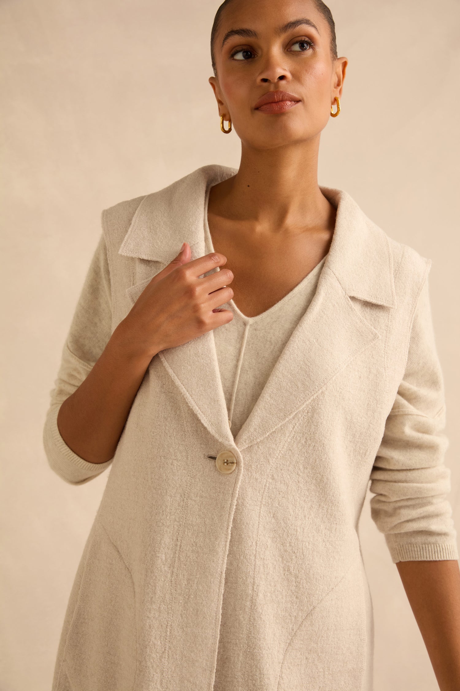 A person wearing a Detachable Fur Long Gilet made of wool blend over a matching V-neck top.