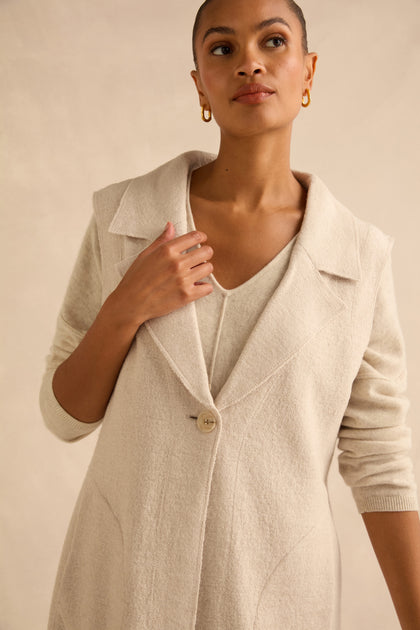 A person wearing a Detachable Fur Long Gilet made of wool blend over a matching V-neck top.