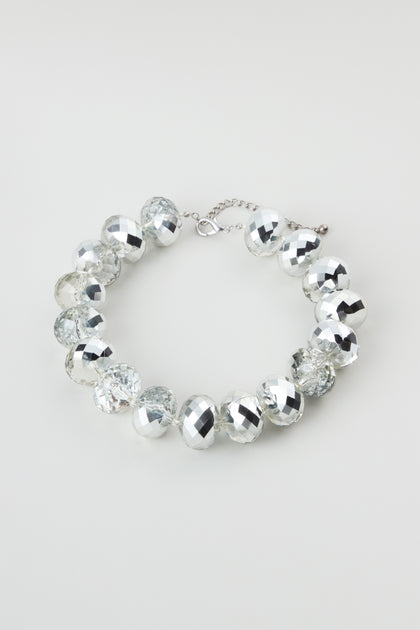 The Silver Disco Necklace shimmers with alternating clear and silver faceted round beads and an adjustable chain clasp, beautifully displayed on a plain light background.