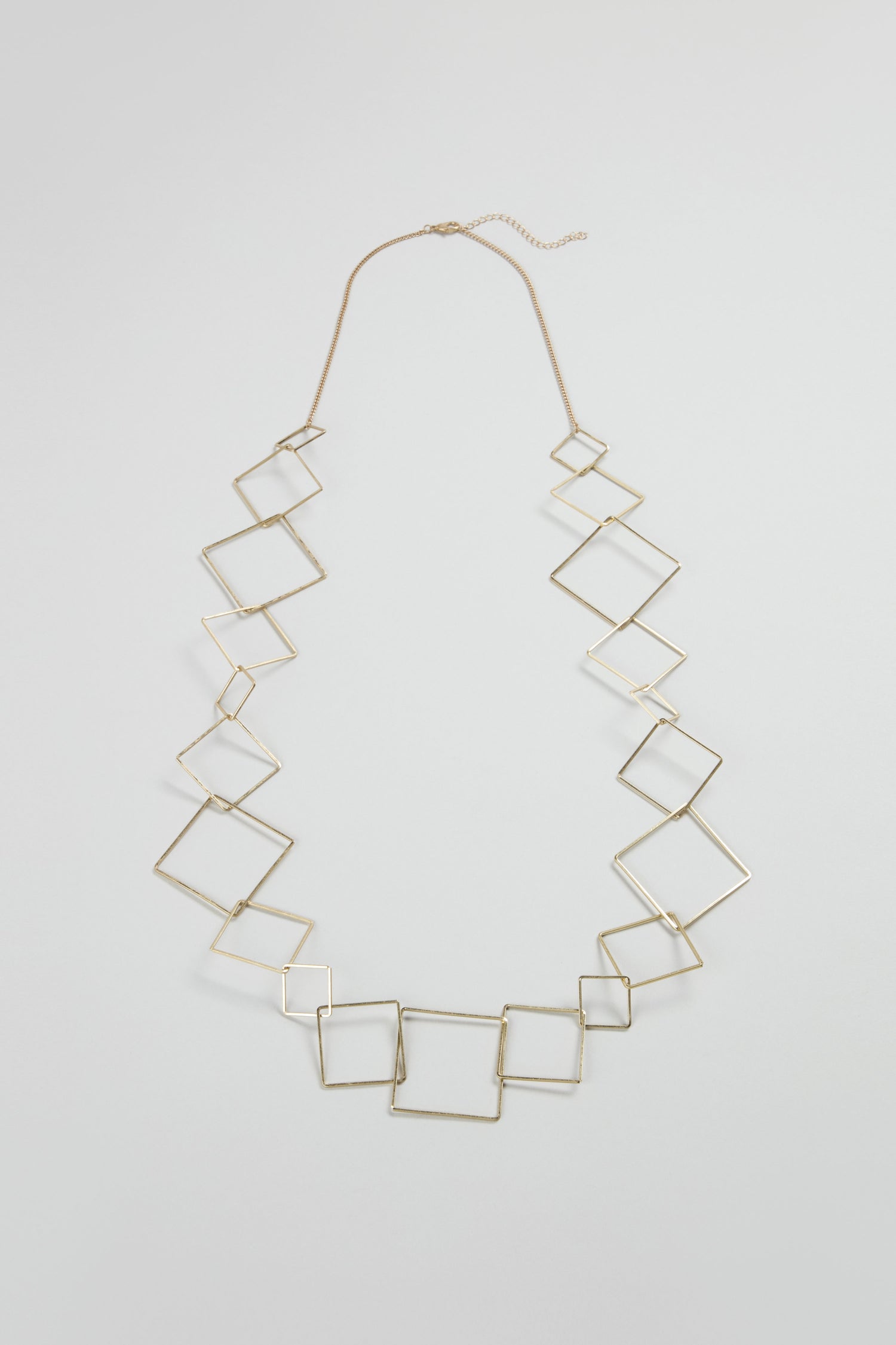 The Gold Long Squares Necklace features interconnected gold-toned open squares on a fine chain, displayed against a plain light background.