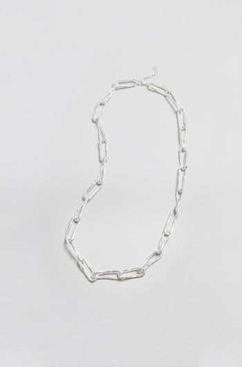 The Long Silver Links Necklace is displayed on a plain, light background. Featuring elongated, rectangular links and a refined, textured chain design, this necklace adds a touch of elegance to any ensemble.