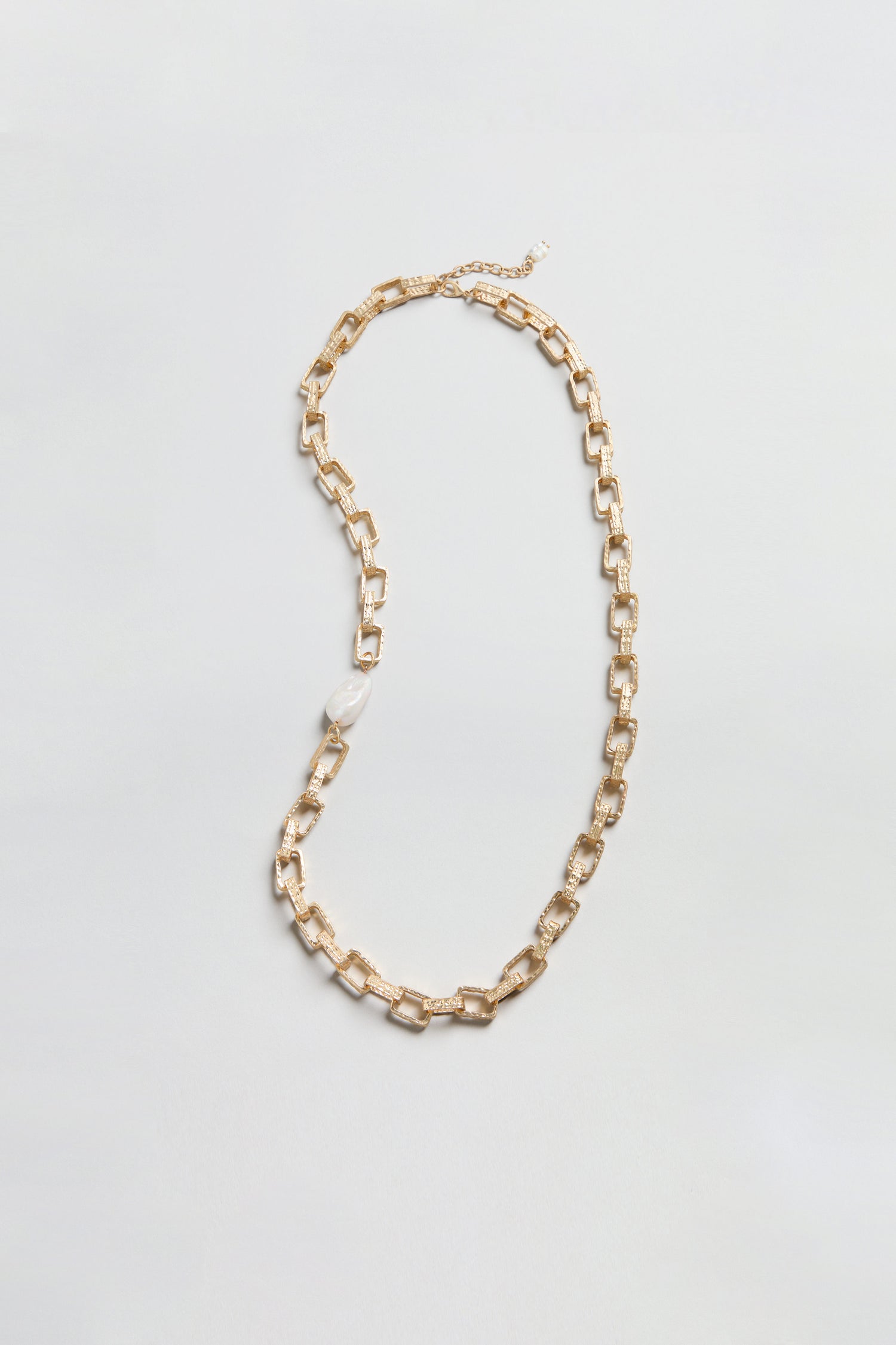 Gold Baroque Pearl Chain Necklace featuring rectangular gold links and a single irregular white baroque pearl, showcased on a simple light background—an elegant accessory that seamlessly merges timeless appeal with modern sophistication.