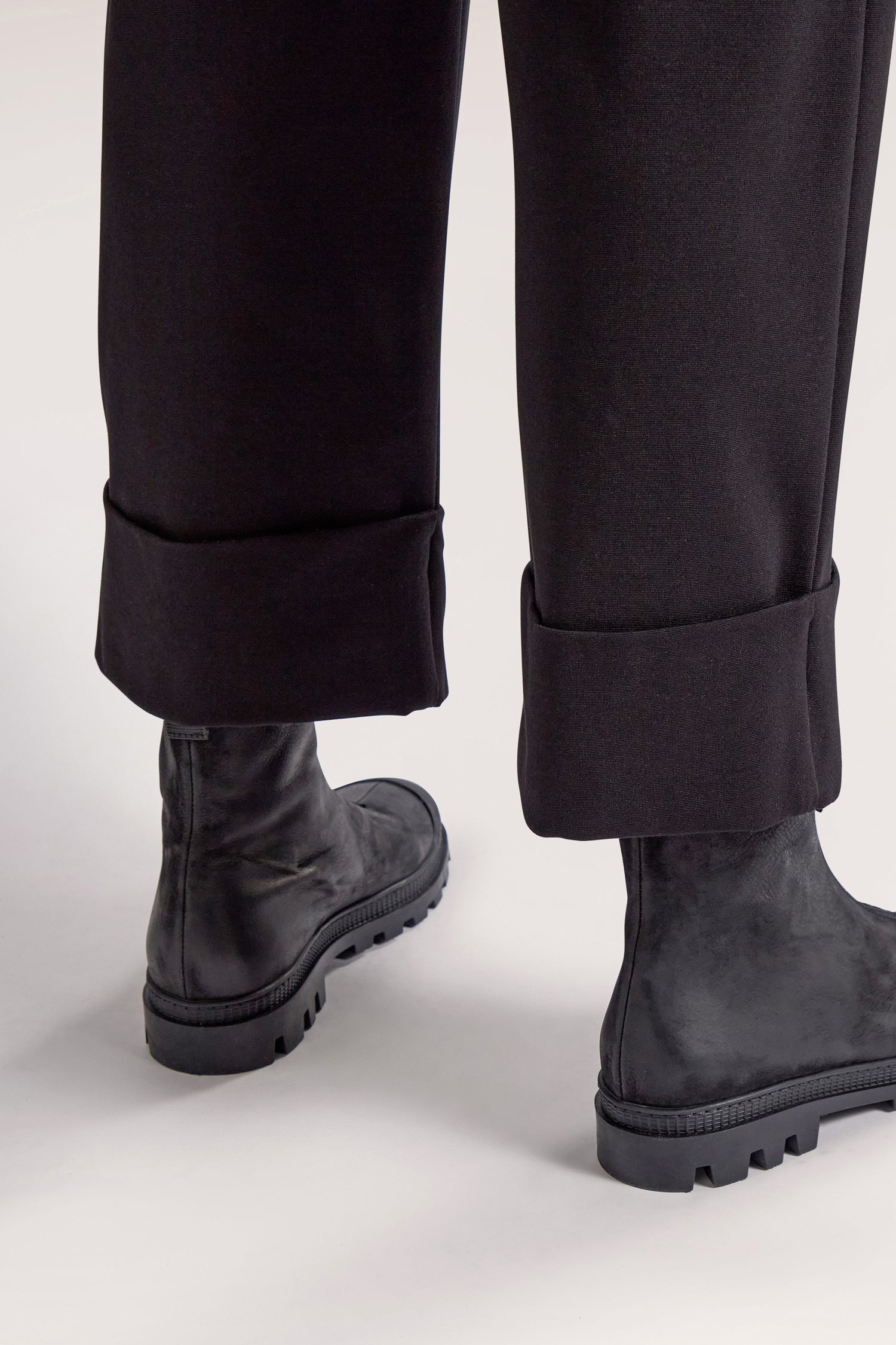 Person wearing black Ponte Cuff Hem Trouser with an elasticated waistband and black military-style boots.