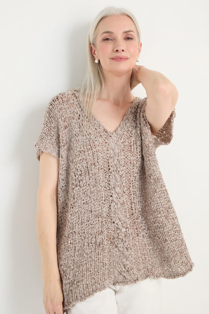 Older woman with long gray hair wears the V-Neck Cotton Blend Knit top in beige and white pants, standing against a plain white background.