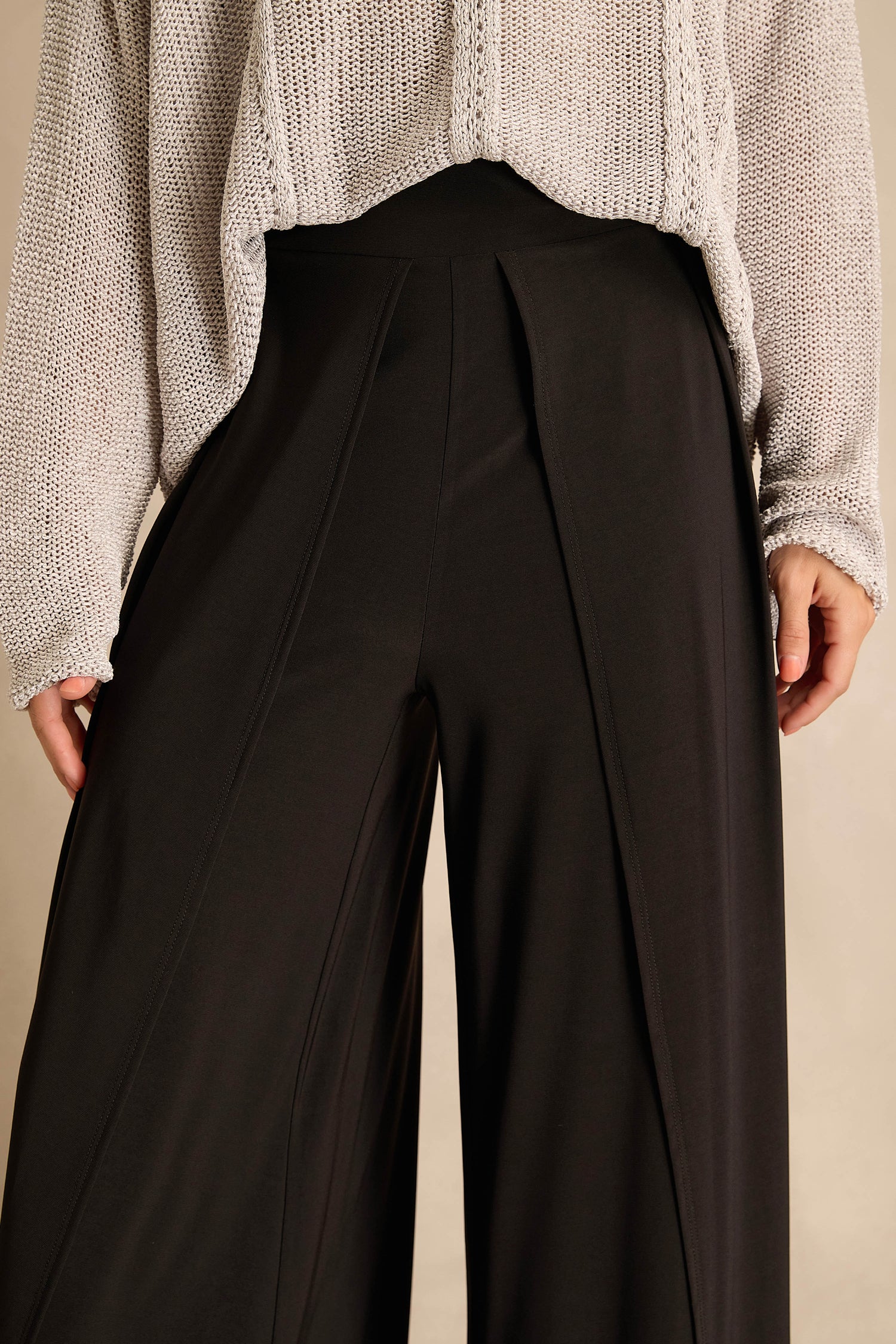 Person wearing a loose-knit light sweater and Wide Leg Wrap Jersey Trousers with a high-waisted, flowing fit, shown from mid-torso to upper thighs.
