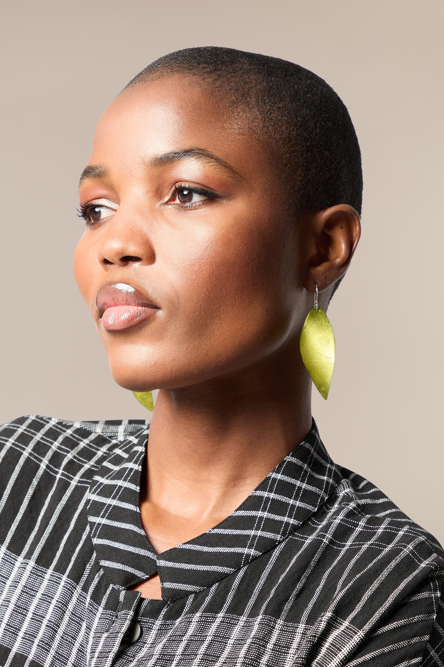A woman wearing a black shirt and a pair of Leaves Earrings.