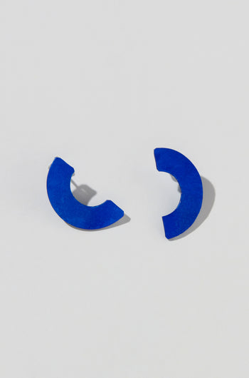 Two Aluminium Crescent Earrings face each other on a light gray background, capturing the sleek design of the OAE399.