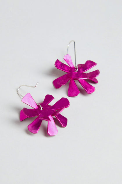 The Flower Earrings feature metallic pink anodised aluminium flowers with sterling silver hooks, showcased against a plain light background.