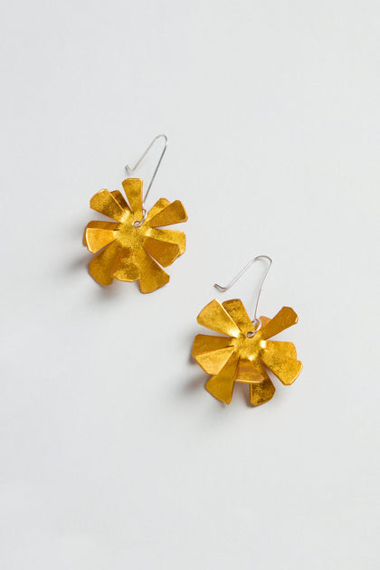 The Flower Earrings feature gold, flower-shaped anodised aluminium with sterling silver hooks, beautifully presented on a plain white background.