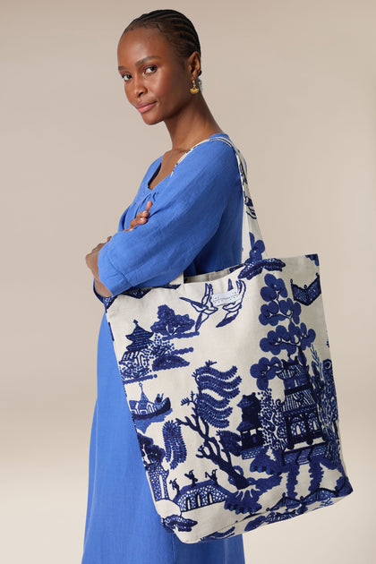 Woman in blue dress posing with a large Willow Canvas Bag.