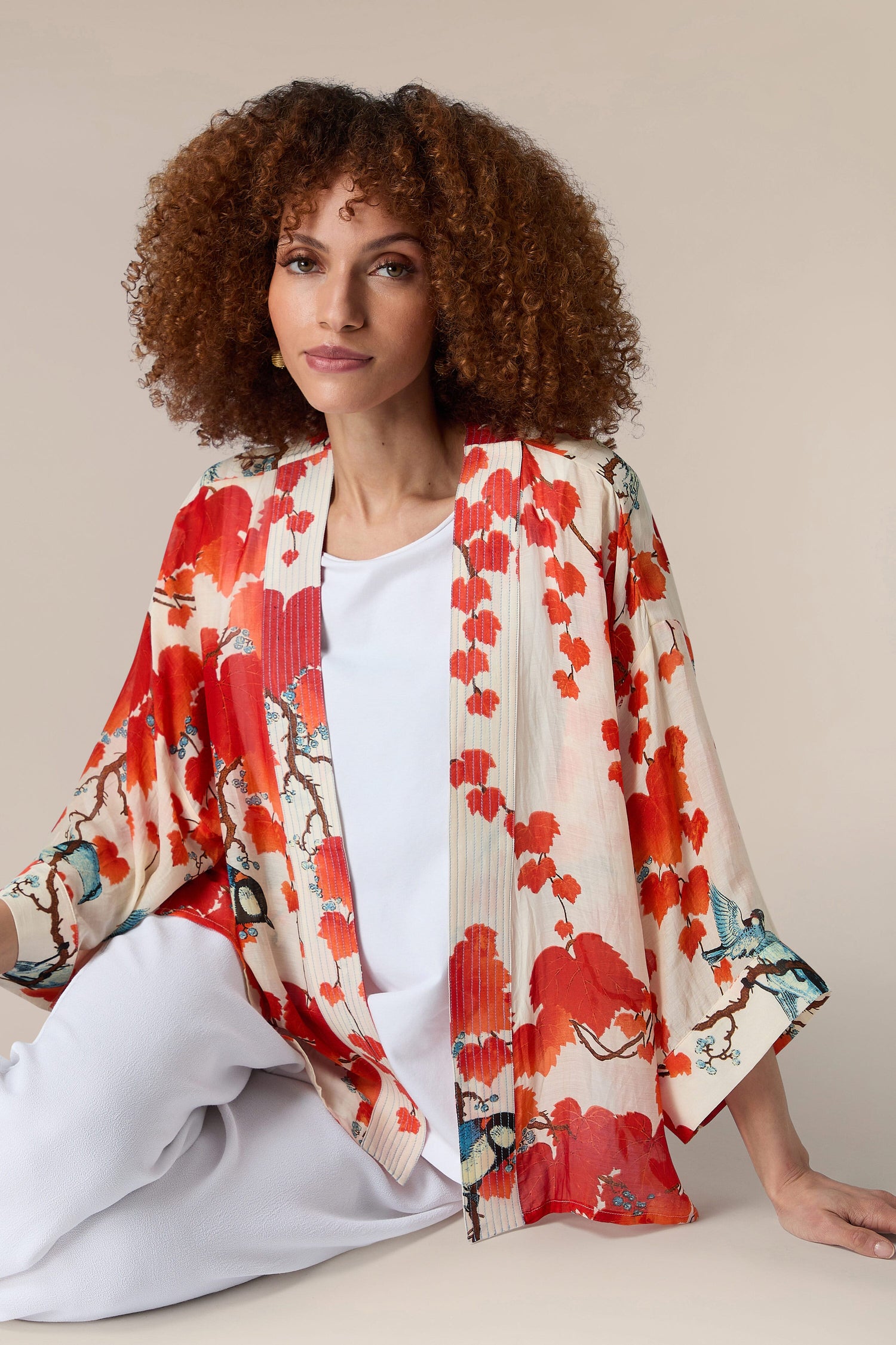 A woman wearing a red Acer Kimono with an embroidered lapel.