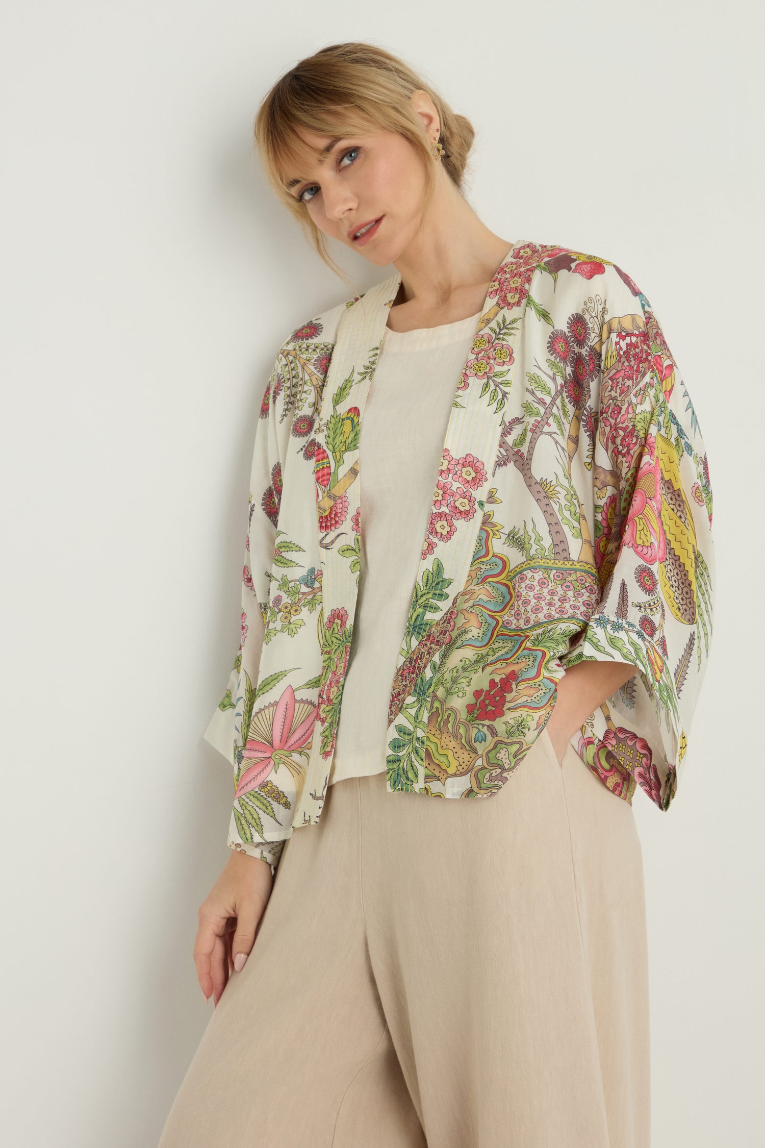 A woman wears the Boho Garden Ecru Print Kimono over a cream top and beige wide-leg pants, standing against a white background.