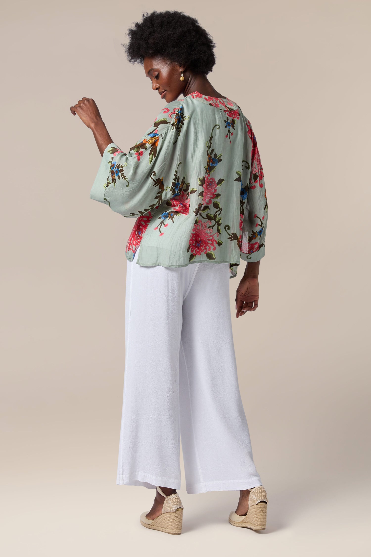 A woman wearing a lightweight floral print Chrysanthemum Kimono with an open front.