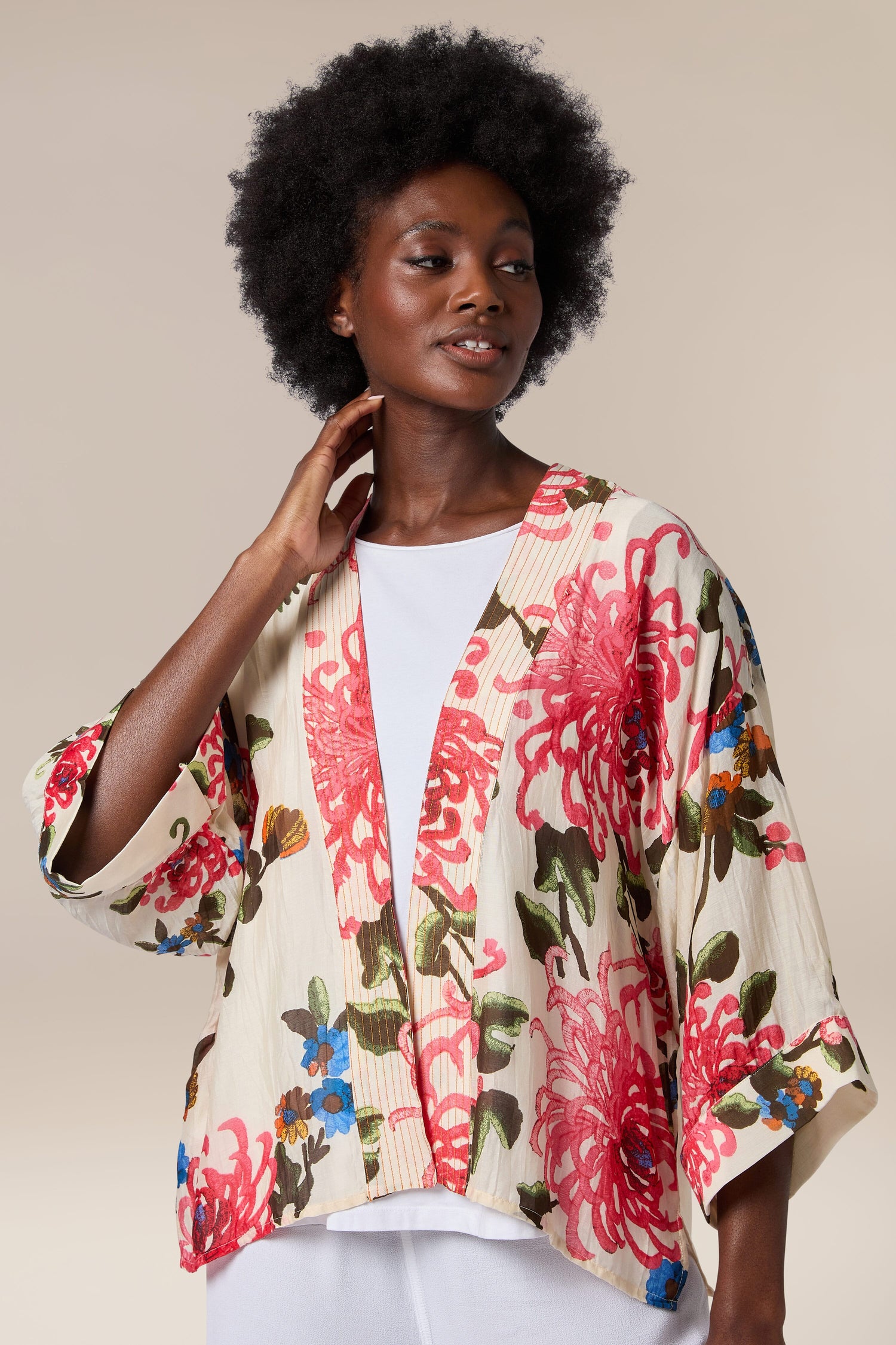 A woman wearing a Chrysanthemum Kimono, a lightweight floral print kimono jacket with an open front.