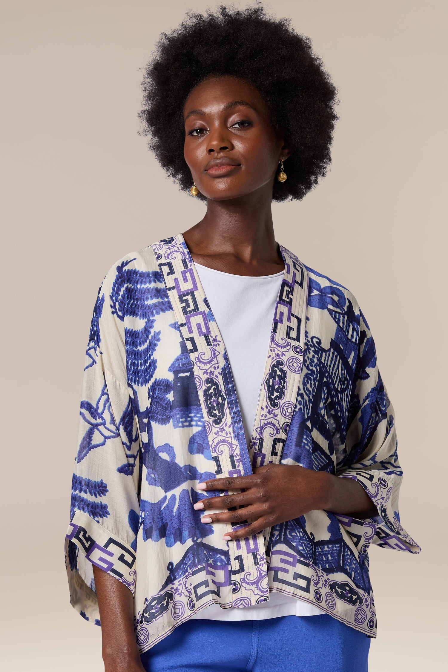 A woman wearing the Willow Kimono, a lightweight kimono jacket with a blue and white print.