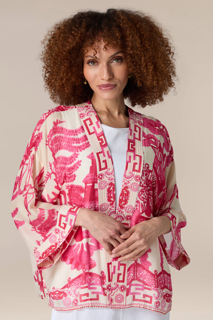 A woman dressed in a vintage pink and white Willow Kimono.