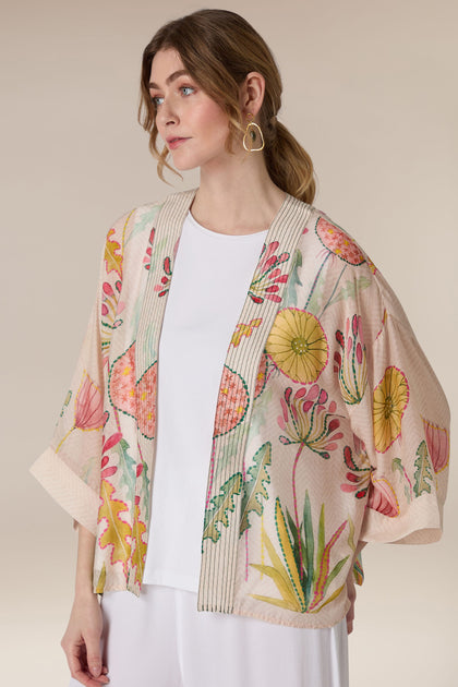 Fashion model showcasing a Pop Flowers Kimono with white top and earrings.